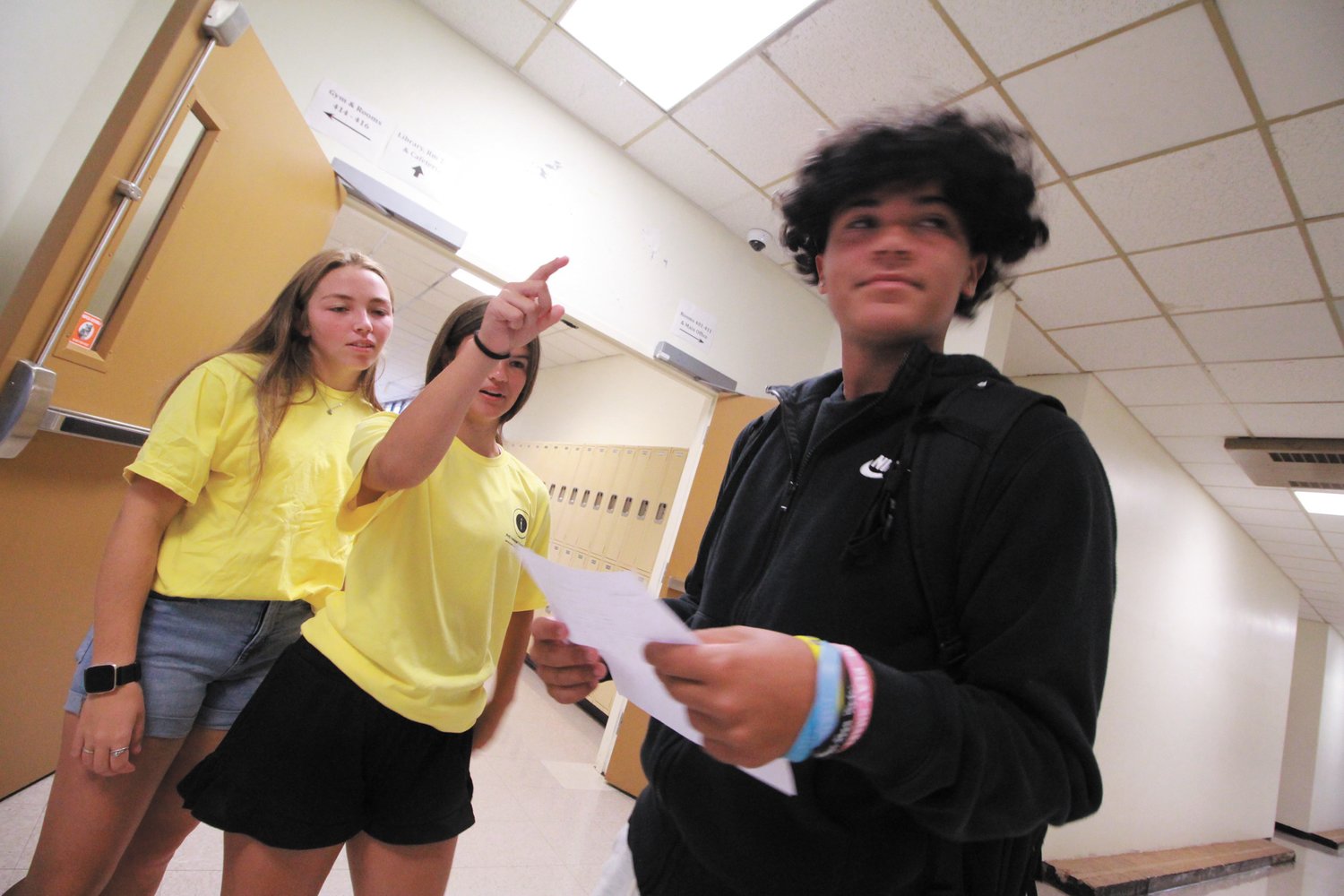THERE TO ASSIST: Pilgrim seniors dressed in matching yellow T-shirts served as guides for freshmen who started classes Wednesday. Here Chloe French and Katie Shaeen assist Manny Rivas.